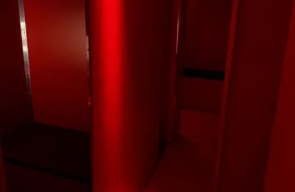 Interior of Erotic Palace, a gay cruise club in Barcelona. Red lighting, dark corners, and suggestive atmosphere for gay men's travel.