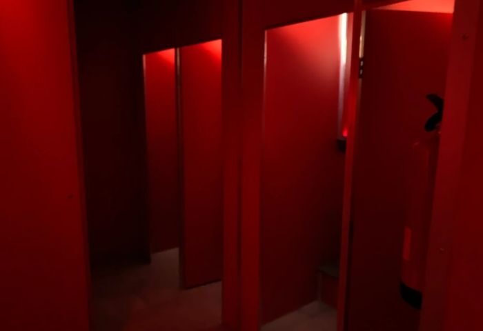 Interior of Erotic Palace, a gay cruise club in Madrid. Red walls and doors create an intimate, maze-like atmosphere. Madrid gay nightlife.