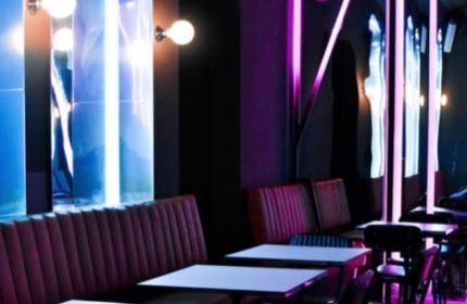 Euforia Bar Milan interior. Chic gay bar with neon lights, plush seating, and modern tables. A trendy spot for gay men's travel in Milan.