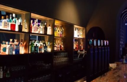 Euforia Bar Milan interior. Shelves stocked with liquor bottles, beer taps. Gay bar scene, nightlife. Milan travel advice.