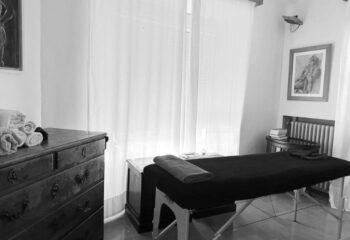 Gay massage in Barcelona: B/W shot of Eugenio's massage room. Massage table, towels, and dresser create a relaxing spa atmosphere.