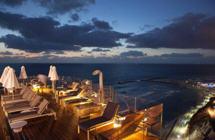 Carlton Tel Aviv Hotel rooftop pool at night. Luxury beach hotel with sea view. Perfect gay travel destination.