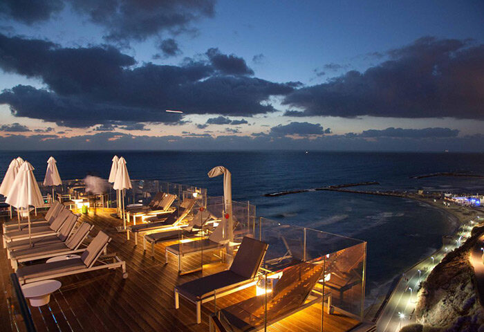 Carlton Tel Aviv Hotel rooftop pool at night. Luxury beach hotel with sea view. Perfect gay travel destination.