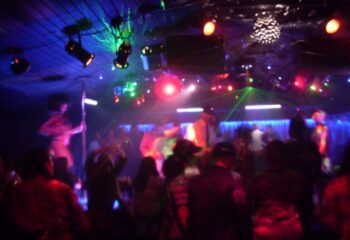 Executive Suite dancefloor: Gay club scene with dancers, vibrant lights, and a lively atmosphere. Nightlife for gay men travel advice.