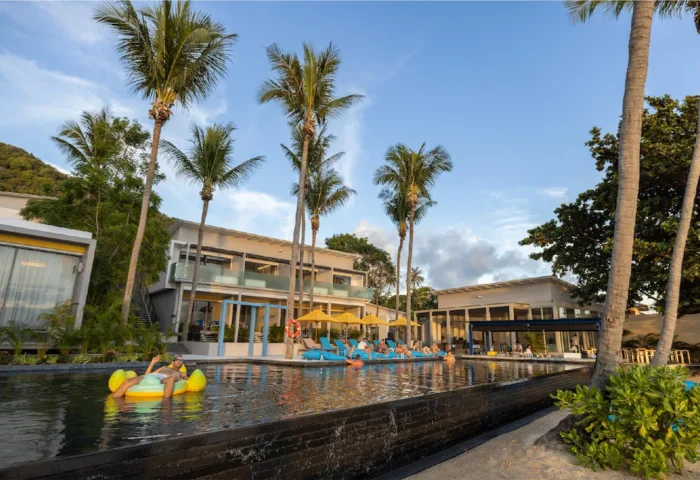 Explora Koh Phangan adults-only resort pool view. Gay-friendly beach hotel with palm trees, lounge chairs, and relaxing atmosphere.