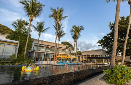 Explora Koh Phangan adults-only resort pool view. Gay-friendly beach hotel with palm trees, lounge chairs, and relaxing atmosphere.
