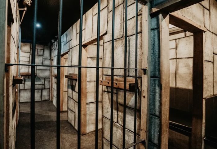 Gay cruise club dungeon. Bars and stone walls create a prison-like atmosphere. Exxxtreme Cruising Club theme for gay men's travel.