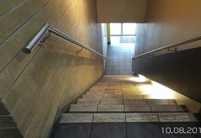 Stairway at F212° Steamworks Gym in Vancouver. Tile steps, stainless steel handrails. A popular gay sauna for men's travel in Canada.