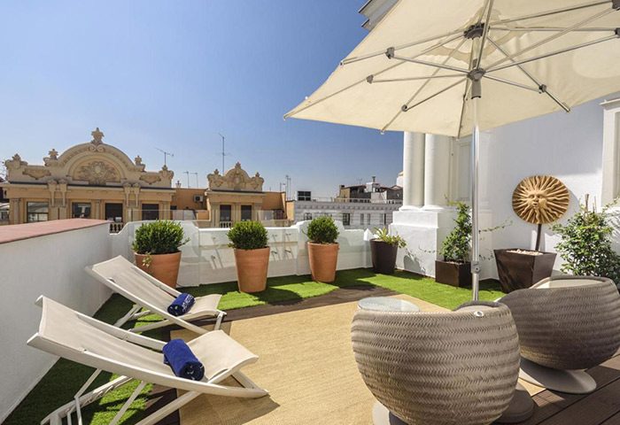 H10 Villa de la Reina Boutique Hotel private terrace in Madrid, Spain. Gay hotel in Chueca near Gran Via. Deck chairs, sun umbrella.