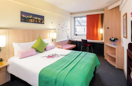 Ibis Praha Wenceslas Square Hotel room. Modern, bright decor. Great cheap gay hotel near Prague gayborhood. Comfy bed, desk, & city view.