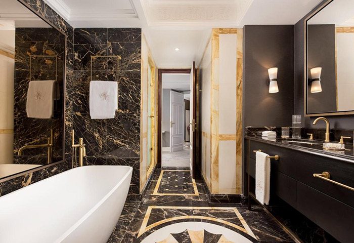 Luxury bathroom at The Westin Palace Madrid, a gay-friendly hotel in Madrid City Center. Black marble, gold accents, & modern fixtures.