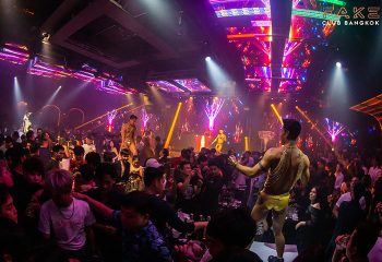 Fake Club Bangkok: Young gay men dance at the best gay club. Dancers perform for a packed crowd with lights and music.