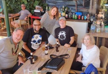 Falcon Long Beach: Group of gay men and women at outdoor bar, drinks, and good times. Gay travel experience, Long Beach location.