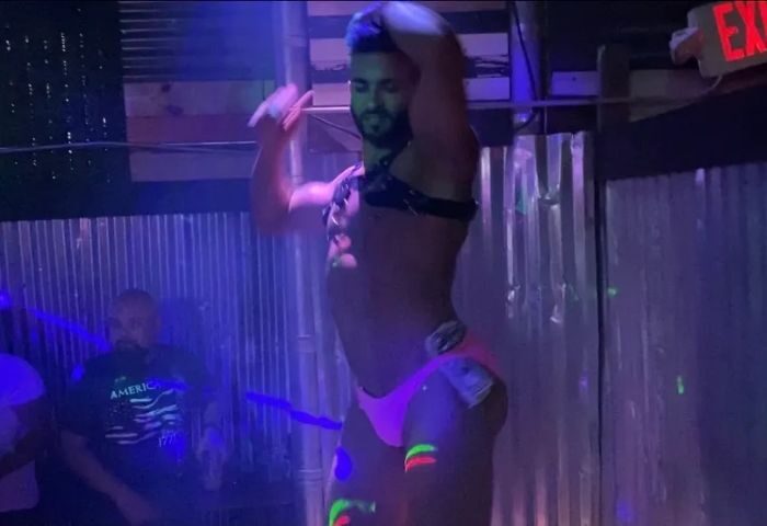 Falcon North performance: Gay male dancer in pink underwear with dollar bills. Nightlife at a gay bar. Travel advice for gay men.