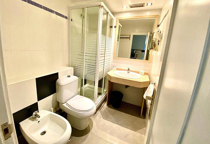 Far Home Gran Via bathroom. Shower, toilet, bidet, and sink in a well-lit bathroom. Most booked gay hotel in Gran Via gayborhood.