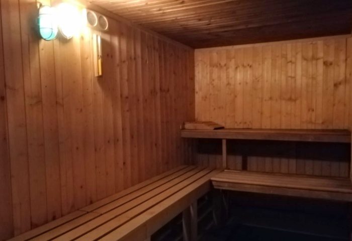 Fenix Sauna Milano interior. Wooden benches and walls create a traditional sauna experience. A relaxing space for gay men's travel.
