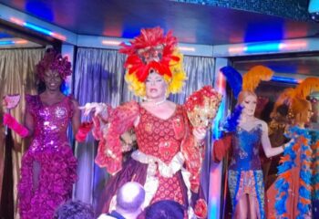 Drag queens perform at Finalmente Club, Lisbon, a gay travel destination. The queens wear colorful, elaborate costumes.