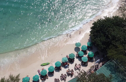 Tubtim Resort, Koh Samet beachfront. Aerial view of the beach, umbrellas, and turquoise water. Gay-friendly hotel near gay bars.