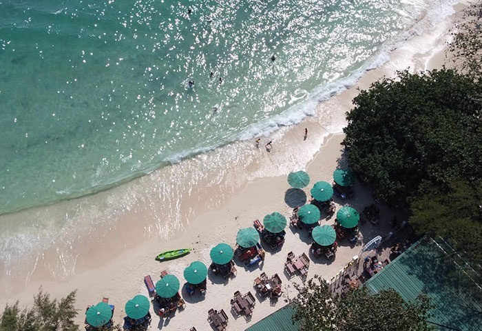 Tubtim Resort, Koh Samet beachfront. Aerial view of the beach, umbrellas, and turquoise water. Gay-friendly hotel near gay bars.