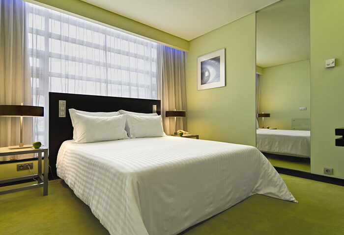 SANA Capitol Hotel room. Lisbon city center gay hotel with double bed, modern design, and green accents. Find cheap 3-star hotels.