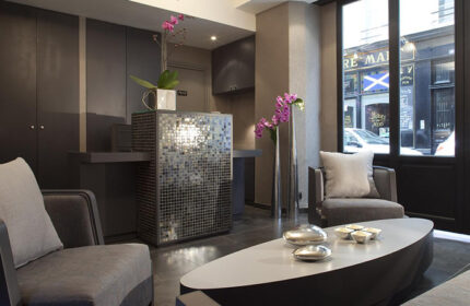 Hotel Caron lobby in Paris near Le Marais gay nightlife. Modern design, mosaic reception desk, stylish seating. Find cheap gay hotels here.