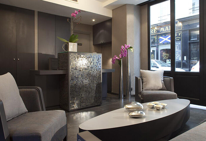 Hotel Caron lobby in Paris near Le Marais gay nightlife. Modern design, mosaic reception desk, stylish seating. Find cheap gay hotels here.