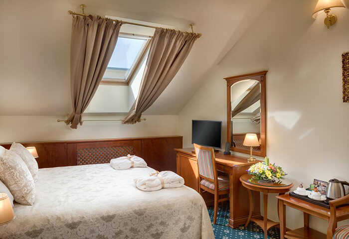 Boutique Hotel Seven Days room in Prague's gayborhood, Vinohrady. Cheap hotels for gay couples. Room with bed, desk, and skylight.