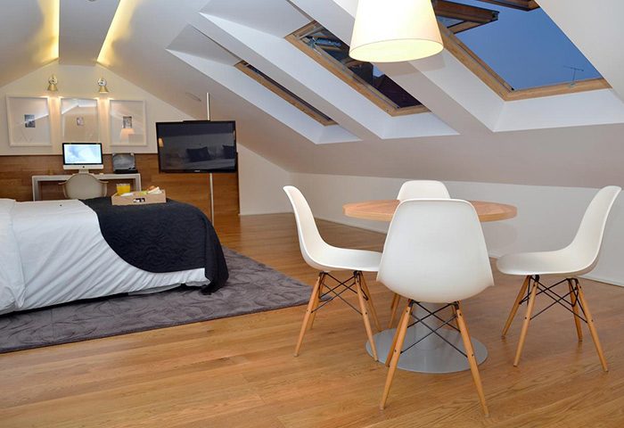 Browns Boutique Hotel room. Lisbon gay hotel near gay nightlife. Higher floor room with skylights, bed, desk, and round table with chairs.