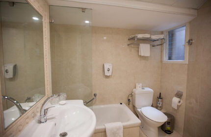 Bathroom at Armon Hayarkon Hotel, a gay-friendly hotel in Tel Aviv near Hilton Beach. Features a sink, toilet, bathtub, and shower. Clean, modern design.