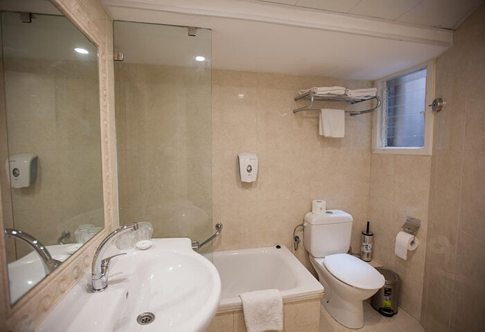 Bathroom at Armon Hayarkon Hotel, a gay-friendly hotel in Tel Aviv near Hilton Beach. Features a sink, toilet, bathtub, and shower. Clean, modern design.