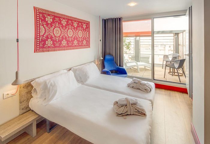 Generator Barcelona hotel room. Twin beds with robes, balcony with chairs. A cheap price gay hotel in Barcelona's party area.