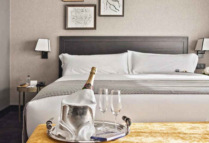The Principal Madrid Hotel room. Champagne & glasses on bed. Luxury gay hotel in Madrid city center gayborhood. Find cheap price.
