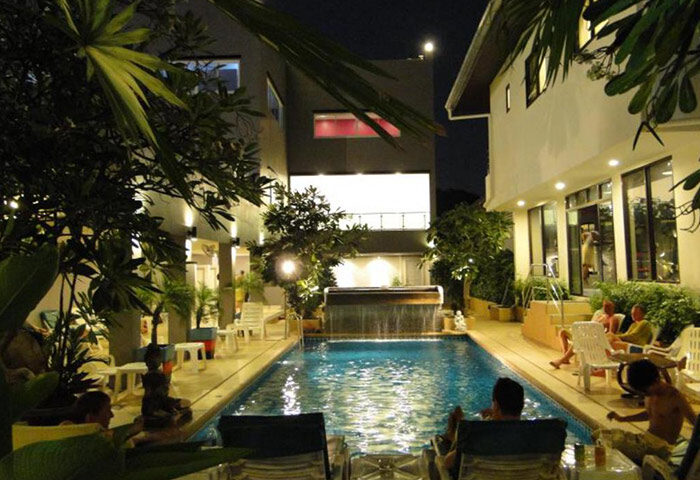 Sansuk Sauna & Guesthouse pool at night. Gay hotel in Pattaya, Thailand. Exclusive gay sauna with men relaxing by the pool.