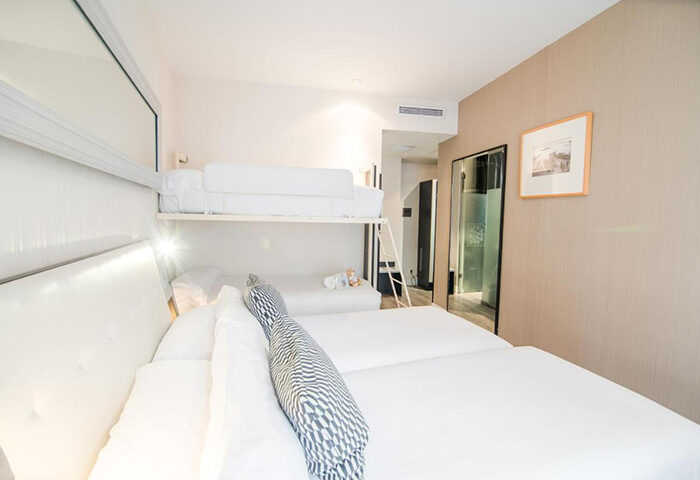 Petit Palace Chueca hotel room for 5 adults in Madrid city center. Gay-friendly hotel with bunk beds and modern design. Gayborhood stay.