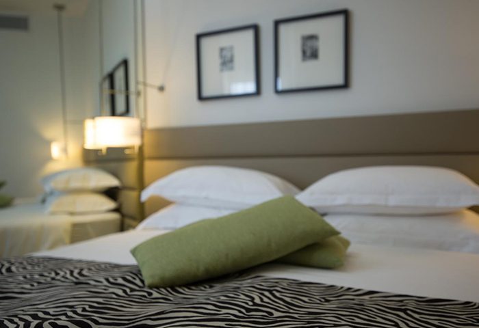 Maxim Design Hotel 3 Star Superior room in Tel Aviv near the gay beach. Hotel room for 3 people with zebra print blanket and green pillows.