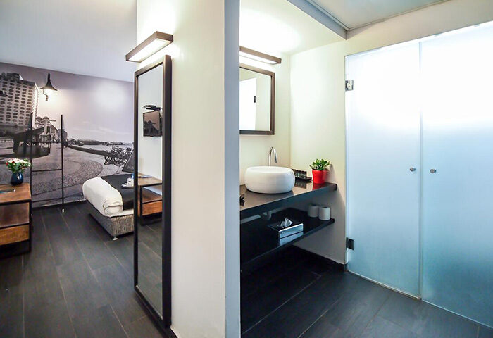 Dizengoff Avenue Boutique Hotel room. Modern design, sleek bathroom, and Tel Aviv cityscape mural. Gay-friendly hotel for 3 people.
