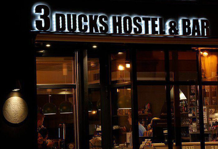 The 3 Ducks Eiffel Tower by Hiphophostels: 3 Ducks Hostel & Bar sign at night. Gay party hostel in Paris city center near Eiffel Tower.