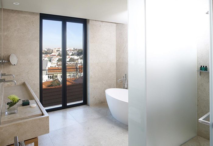 Memmo Principe Real Design Hotel bathroom. Luxury gay hotel in Lisbon near gay bars, featuring a modern bathtub and city view.