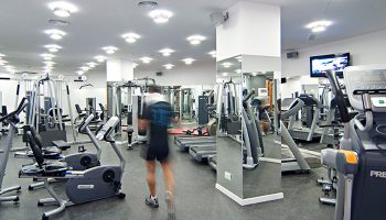 Gym at Axel Hotel Barcelona, a gay adults-only hotel in Eixample. Fitness equipment, treadmills, and a man exercising.