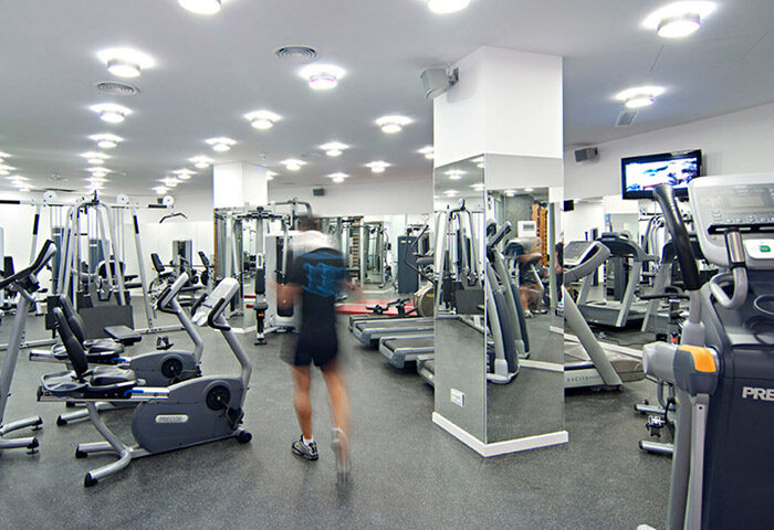 Gym at Axel Hotel Barcelona, a gay adults-only hotel in Eixample. Fitness equipment, treadmills, and a man exercising.