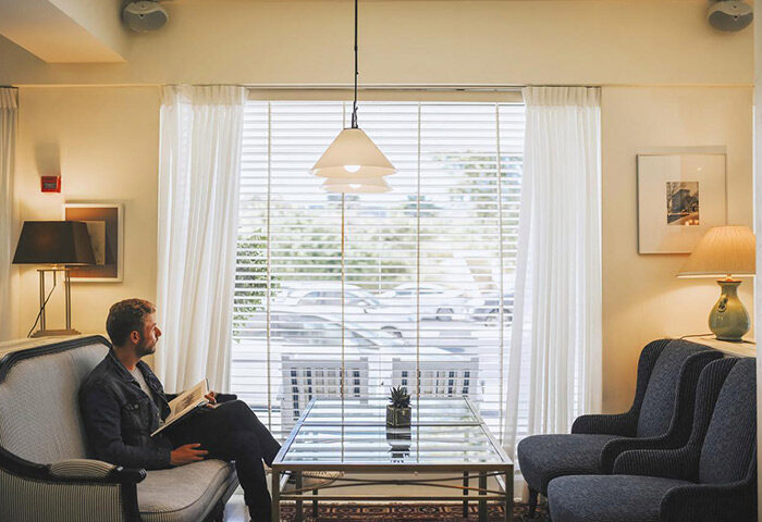 Shalom Hotel & Relax: Man reading in a living room of a room for 3 people at this gay-friendly hotel near Hilton Beach, Tel Aviv.