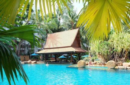 Avani Pattaya Resort pool view. Thai-style bar, blue water, palm trees. Gay-friendly hotel near gay bars in Pattaya, Thailand.