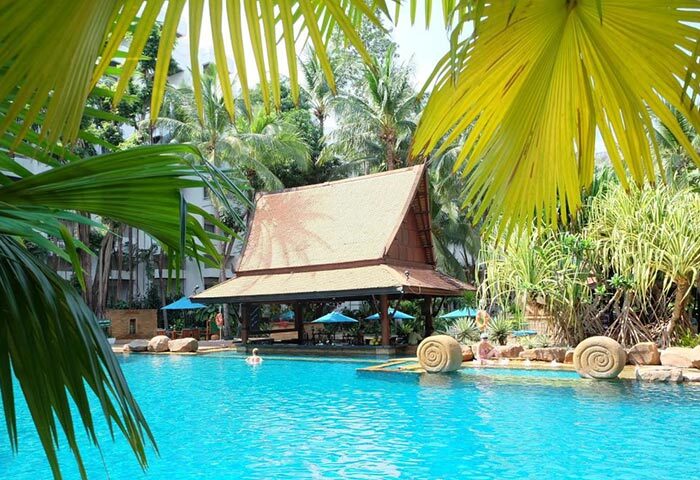 Avani Pattaya Resort pool view. Thai-style bar, blue water, palm trees. Gay-friendly hotel near gay bars in Pattaya, Thailand.