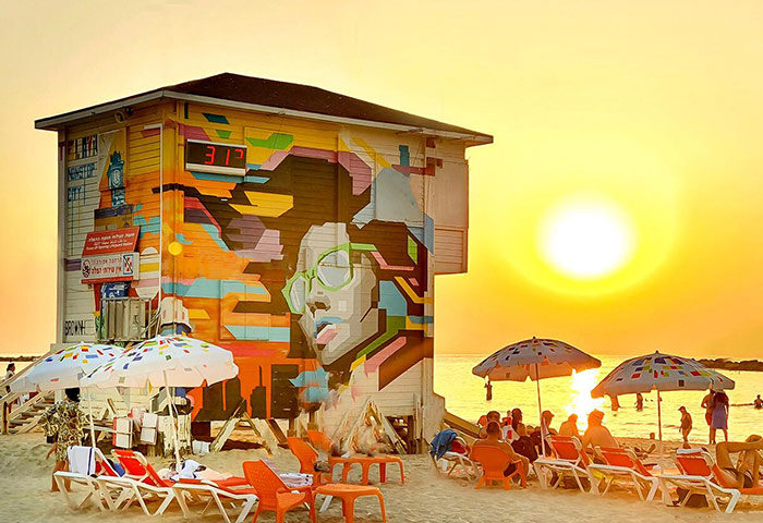 Tel Aviv's Hilton Gay Beach lifeguard tower art at sunset. Find apartments near this popular gay travel spot. Two-bedroom penthouse rentals.