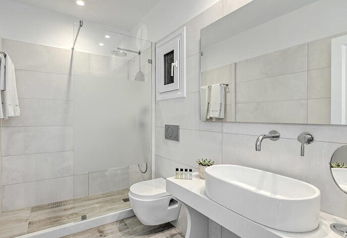 Hotel Alkyon, Mykonos Town: White-themed bathroom. Modern design with shower, toilet, sink, and mirror. Gay-friendly hotel. Find luxury here.