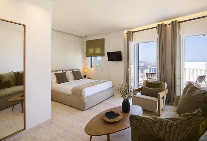 Vencia Boutique Hotel, Mykonos Town. Room interior with bed, seating area, balcony, and sea view. Gay-friendly hotel.