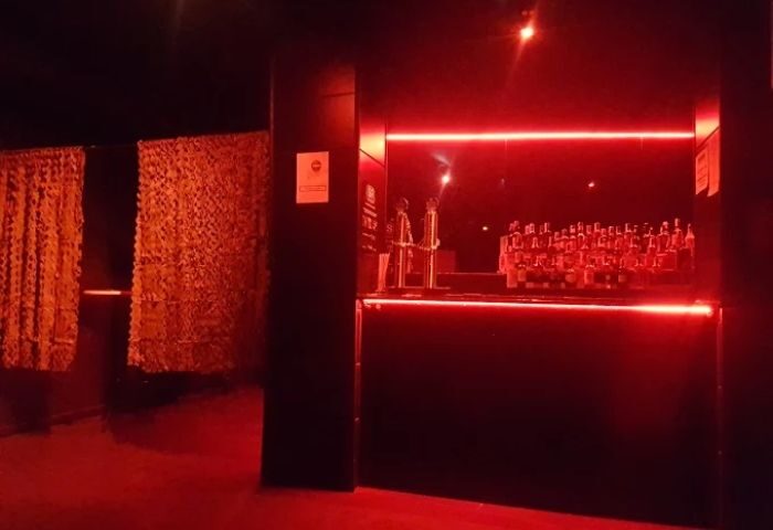Interior of Firewood Gay Cruise Club in Madrid, Spain. Red lighting illuminates the bar area and curtains. Gay travel destination.