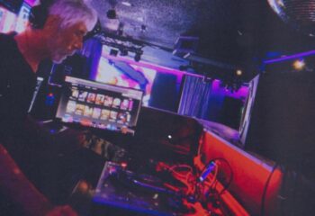 Flex Cocktail Lounge in Las Vegas: DJ spinning music at a gay bar. Nightlife scene with stage, lights, & entertainment. Gay travel advice.