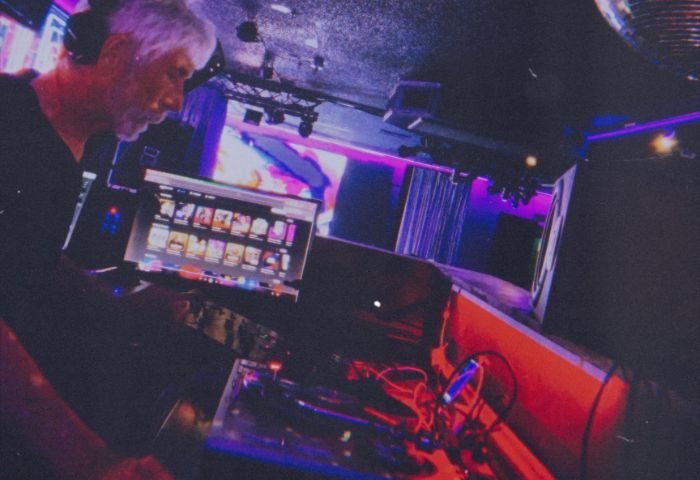 Flex Cocktail Lounge in Las Vegas: DJ spinning music at a gay bar. Nightlife scene with stage, lights, & entertainment. Gay travel advice.