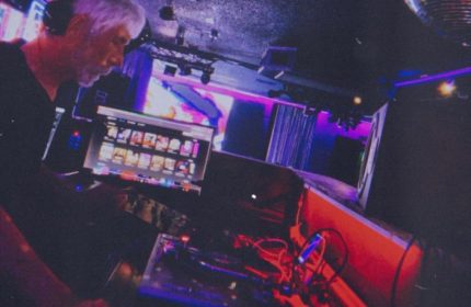 Flex Cocktail Lounge in Las Vegas: DJ spinning music at a gay bar. Nightlife scene with stage, lights, & entertainment. Gay travel advice.